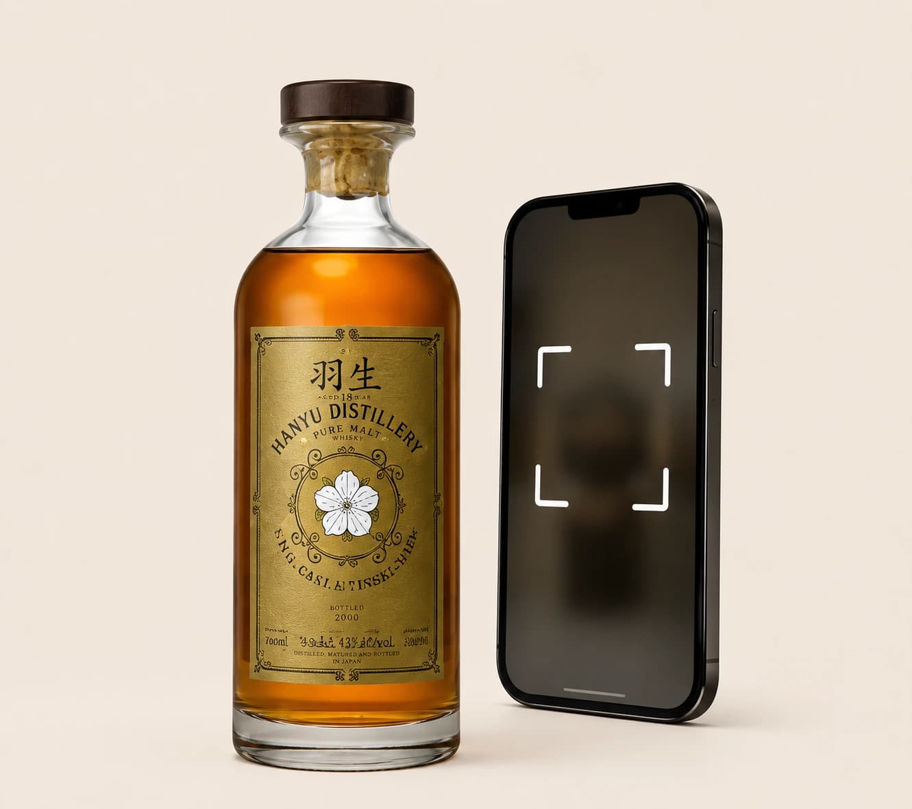A whisky bottle next to a phone scanning frame